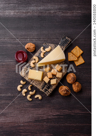 Aged cheese in a triangular block with jam, figs, and nuts. Aged cheese Aged cheese in a triangular block with jam, figs, and nuts. Aged cheese 140088800