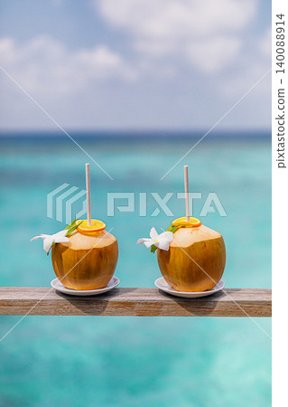 Two coconut drinks straws turquoise lagoon ocean background idyllic vacation concept gorgeous tropical refreshing summer beverage paradise beach getaway relaxation breathtaking serene exotic Two coconut drinks straws turquoise lagoon ocean background idyllic vacation concept gorgeous tropical refreshing summer beverage paradise beach getaway relaxation breathtaking serene exotic 140088914