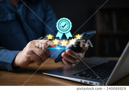 Excellent quality service and certification concept,hand hold smartphone with five star and verified badge.Customer satisfaction rating,product standard,brand excellence,business reputation,compliance 140088929