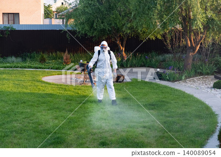 Spring garden pest control: man in protective suit spraying plants Spring garden pest control: man in protective suit spraying plants 140089054