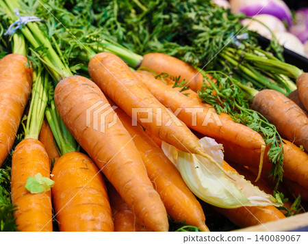 Orange carrots with green leaves in market. Vegetables background Orange carrots with green leaves in market. Vegetables background 140089067