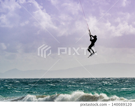 Kite surfer riding waves. Kiteboarding sport. 140089120
