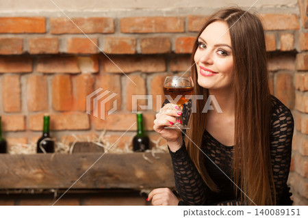 Woman tasting wine in rural cottage interior 140089151