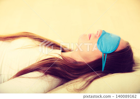 Brunette woman sleeping in blue eye sleep mask 140089162