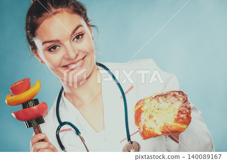 Dietitian with sweet roll bun and vegetables. 140089167