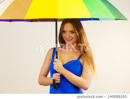Woman in summer dress holds colorful umbrella Woman in summer dress holds colorful umbrella 140089205