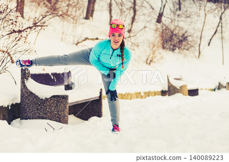 Girl exercising in winter park Girl exercising in winter park 140089223