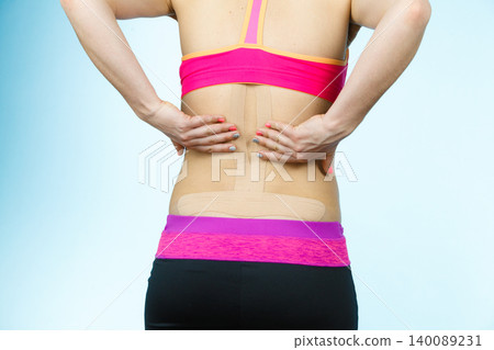 Woman with medical kinesio taping on back Woman with medical kinesio taping on back 140089231