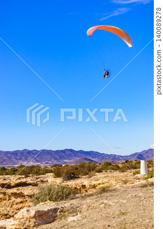 Paraglider soars above hills in clear weather, Spain Paraglider soars above hills in clear weather, Spain 140089278