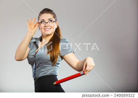 Teacher looking elegant woman holding big pencil Teacher looking elegant woman holding big pencil 140089322