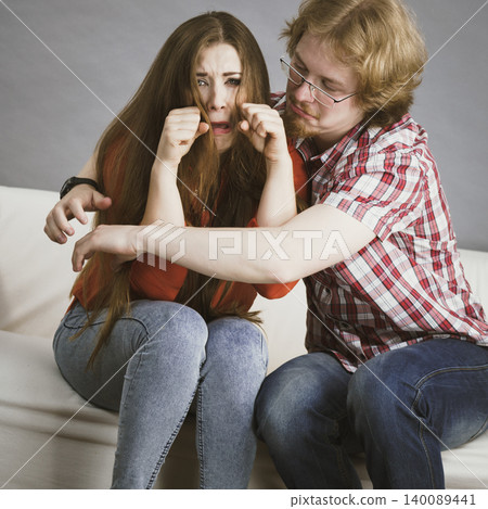 Woman confiding to man on sofa Woman confiding to man on sofa 140089441