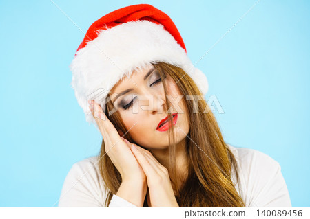 Woman in santa hat being sleepy Woman in santa hat being sleepy 140089456
