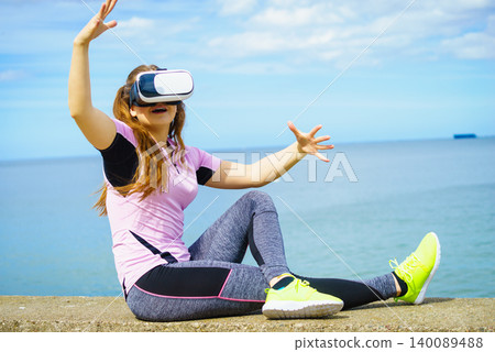 Woman wearing VR outside Woman wearing VR outside 140089488
