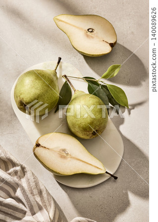 Fresh Green Pears Whole and Halved on Wooden Cutting Board. Top View Fresh Green Pears Whole and Halved on Wooden Cutting Board. Top View 140089626