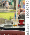 Used coffee cups, empty smoothie glass, straw, saucers, dishes remain on cafe table after coffee break. Concept of coffee break ending, cleanup, cafe waste, leisure, drink service, copy space 140089760