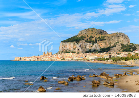 Picturesque Mediterranean coastal town nestled beneath a dramatic rocky mountain Picturesque Mediterranean coastal town nestled beneath a dramatic rocky mountain 140089868