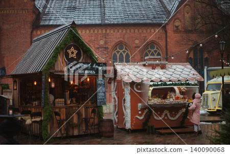 Traditional Christmas market wooden stalls with red and white striped roofs in Old Riga Traditional Christmas market wooden stalls with red and white striped roofs in Old Riga 140090068