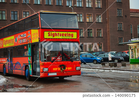 Red double-decker sightseeing bus parked on a damp Red double-decker sightseeing bus parked on a damp 140090175