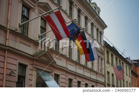 International flags hanging from a classic pastel building facade International flags hanging from a classic pastel building facade 140090177