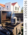 Open grill with charcoal chimney and smoke stands in backyard 140090196