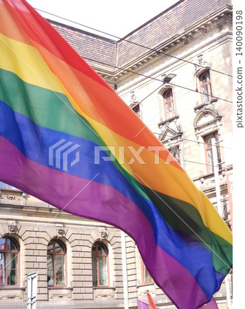 Rainbow pride flag waves in front of historic city building. Concept of LGBTQ rights 140090198