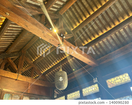 A traditional Japanese-style cafe with wooden roof beams, retro lighting, and a ceiling space bathed in sunlight. A traditional Japanese-style cafe with wooden roof beams, retro lighting, and a ceiling space bathed in sunlight. 140090280