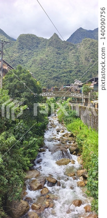 A turbulent mountain river surrounded by the tropical forests of the town of Aguas Calientes A turbulent mountain river surrounded by the tropical forests of the town of Aguas Calientes 140090756