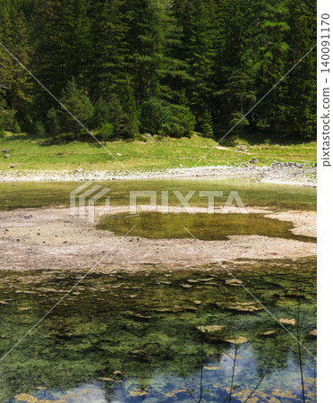 Seasonal emerald alpine lake Gruner See in Styria, Austria, highlighting fragile alpine habitats under environmental stress. Seasonal emerald alpine lake Gruner See in Styria, Austria, highlighting fragile alpine habitats under environmental stress. 140091170