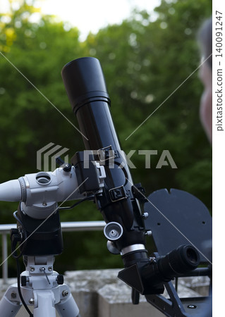 Astronomy telescope on a tripod in use, illustrating science education and hands on learning tools for exploring the night sky. Astronomy telescope on a tripod in use, illustrating science education and hands on learning tools for exploring the night sky. 140091247