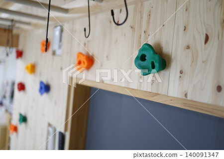 Colorful bouldering holds on a wooden wall installed at home. Colorful bouldering holds on a wooden wall installed at home. 140091347