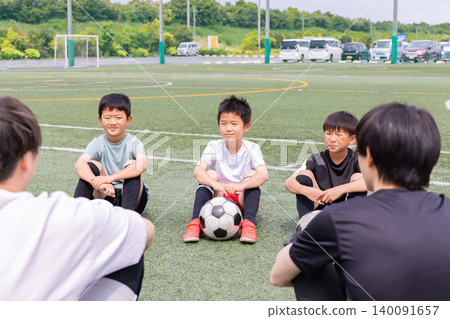 Boys holding a huddle meeting with their soccer coach. Boys holding a huddle meeting with their soccer coach. 140091657