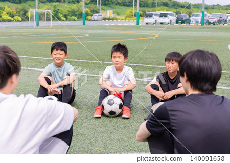 Boys holding a huddle meeting with their soccer coach. Boys holding a huddle meeting with their soccer coach. 140091658