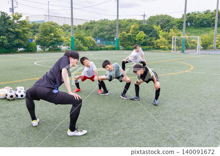 A boys' team stretching before soccer practice. A boys' team stretching before soccer practice. 140091672