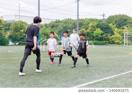 一支男子足球隊在訓練前進行伸展運動。 一支男子足球隊在訓練前進行伸展運動。 140091675