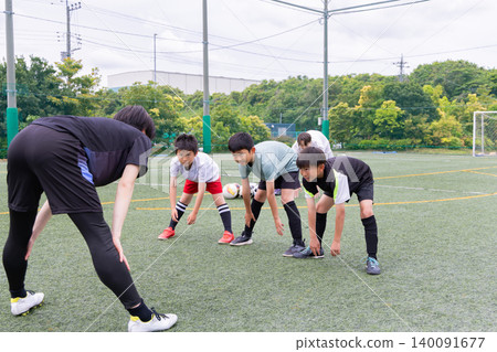 A boys' team stretching before soccer practice. A boys' team stretching before soccer practice. 140091677