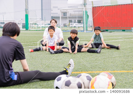 一支男子五人制足球隊和他們的男教練在訓練中做伸展運動。 一支男子五人制足球隊和他們的男教練在訓練中做伸展運動。 140091686