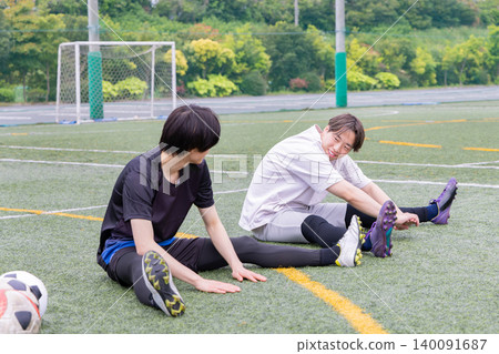 Male player stretching on a futsal court Male player stretching on a futsal court 140091687