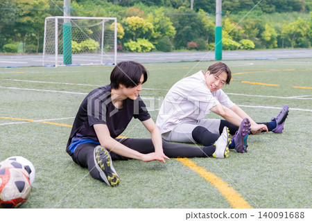 Male player stretching on a futsal court Male player stretching on a futsal court 140091688