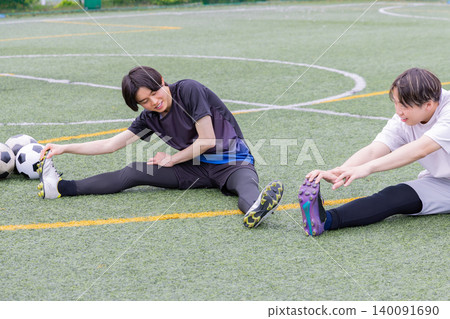 一名男球員在五人制足球場上做伸展運動 一名男球員在五人制足球場上做伸展運動 140091690