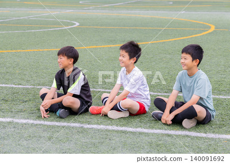 Boys sitting and listening during soccer practice Boys sitting and listening during soccer practice 140091692
