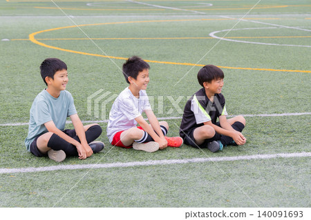 Boys sitting and listening during soccer practice Boys sitting and listening during soccer practice 140091693