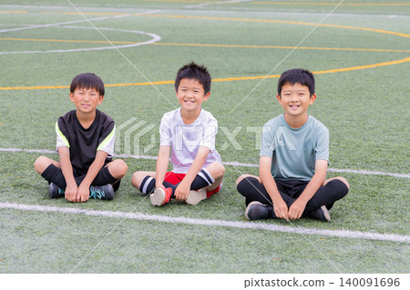 Boys sitting and listening during soccer practice Boys sitting and listening during soccer practice 140091696