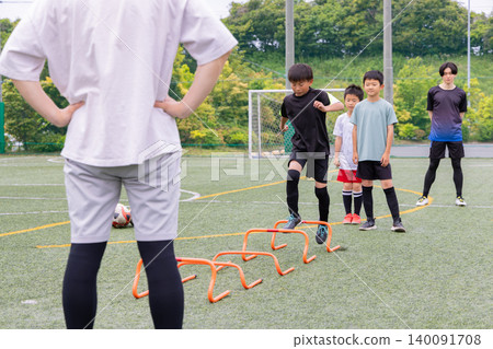 Boys doing ladder training during futsal practice with their male coach Boys doing ladder training during futsal practice with their male coach 140091708
