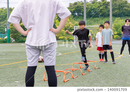 Boys doing ladder training during futsal practice with their male coach Boys doing ladder training during futsal practice with their male coach 140091709