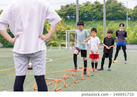 男孩們在五人制足球訓練期間,和他們的男教練一起進行梯子訓練。 男孩們在五人制足球訓練期間,和他們的男教練一起進行梯子訓練。 140091710