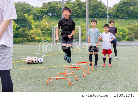 Boys doing ladder training during futsal practice with their male coach 140091715