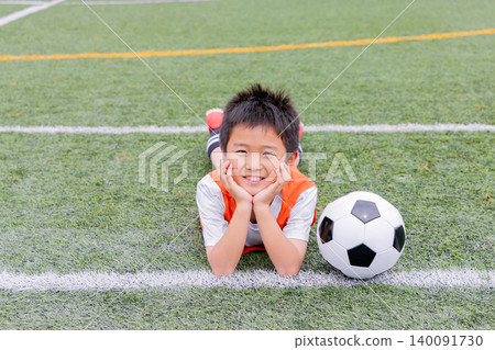 A young athlete smiles with a soccer ball. 140091730