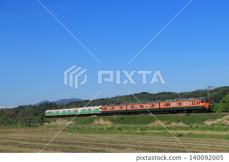 2026 年 5 月 7 日，一列 115 系列列車（復古塗裝）在北信濃線上行駛，背景是春天白雪皚皚的阿爾卑斯山。 140092005