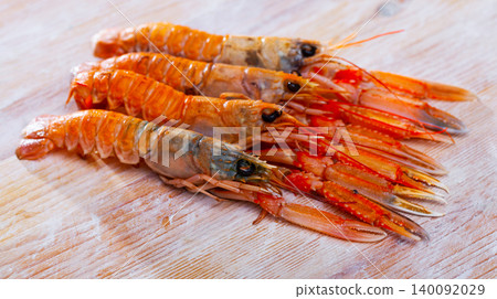 Raw Norway lobster on wooden table Raw Norway lobster on wooden table 140092029