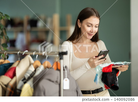 Young woman scanning QR-code on panties in clothing store 140092086